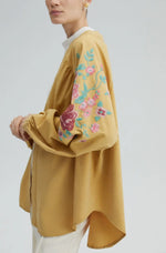 Kimono jacket in a dusty curry with flower embroidery.
